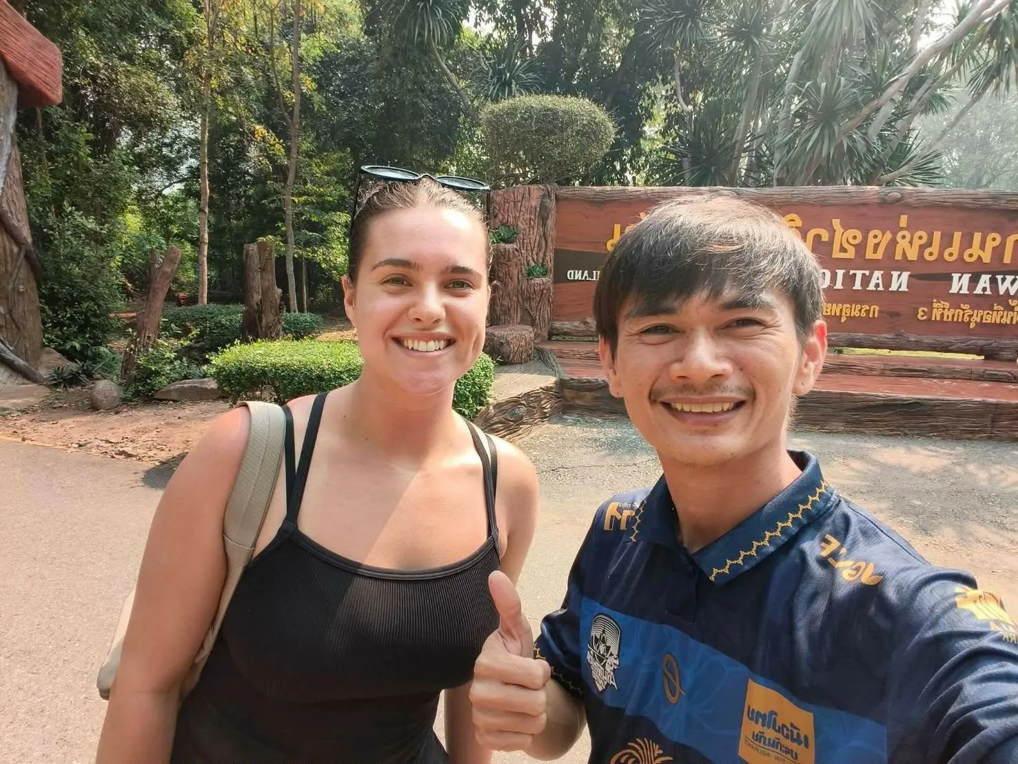 Nong with a guest at the Erawan National Park entrance sign