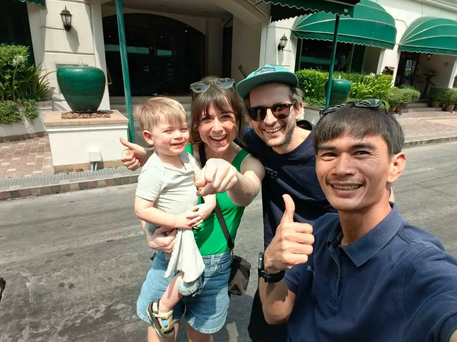 Nong with a young family and their toddler outside their hotel