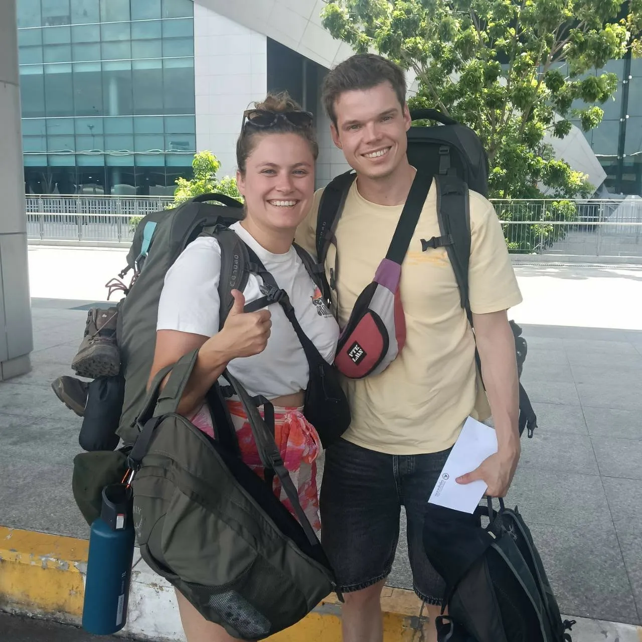 Two backpackers with their rucksacks after an airport pick-up