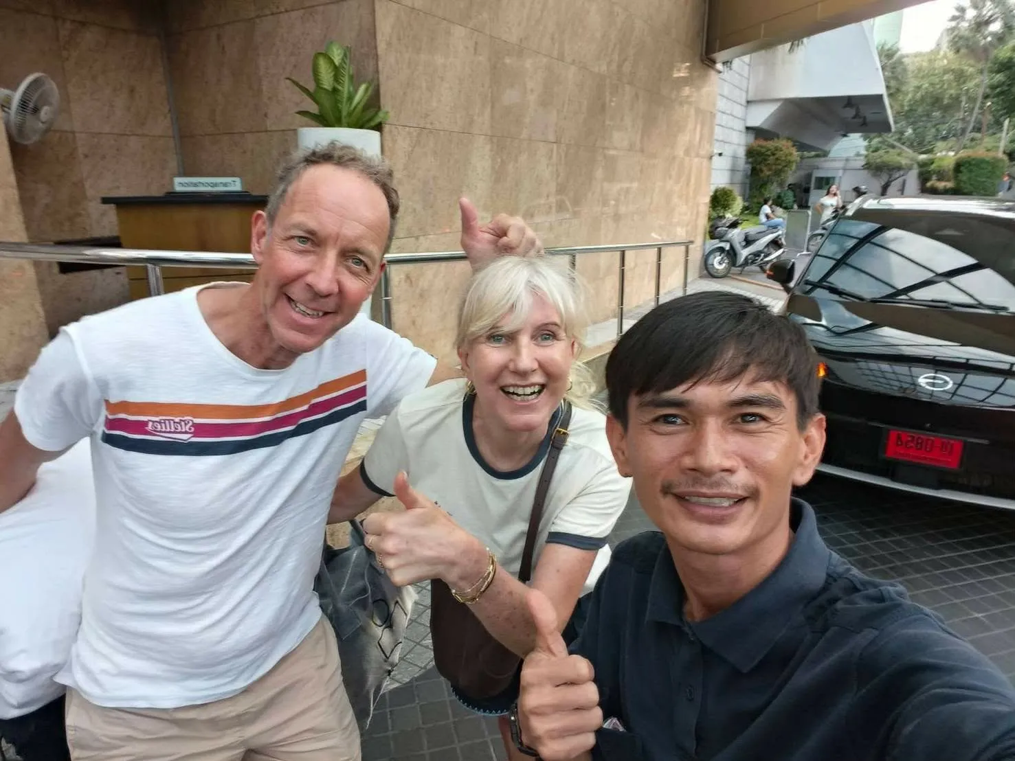 Nong with two guests outside their hotel before a day trip