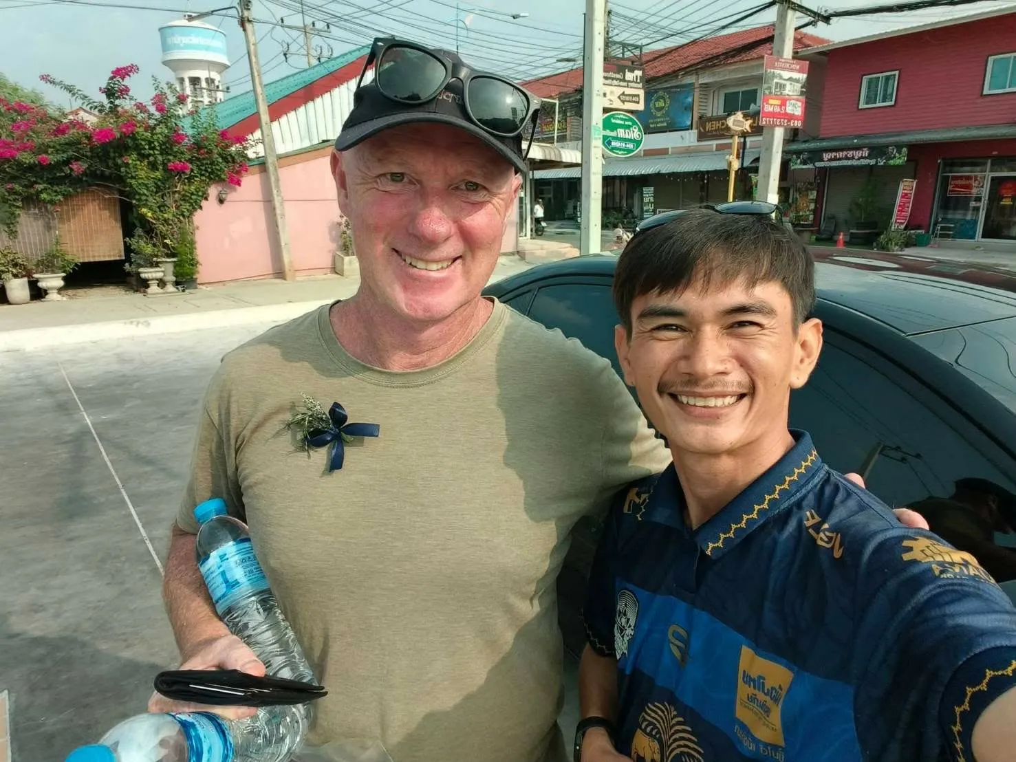 Nong with a guest beside the car in Kanchanaburi town